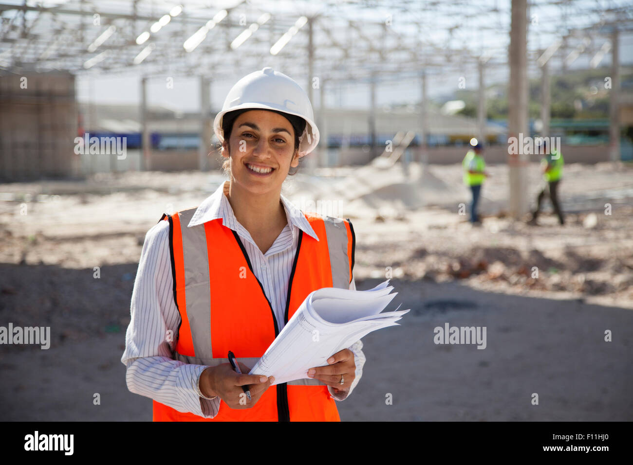 Architect holding blueprints at construction site Stock Photo