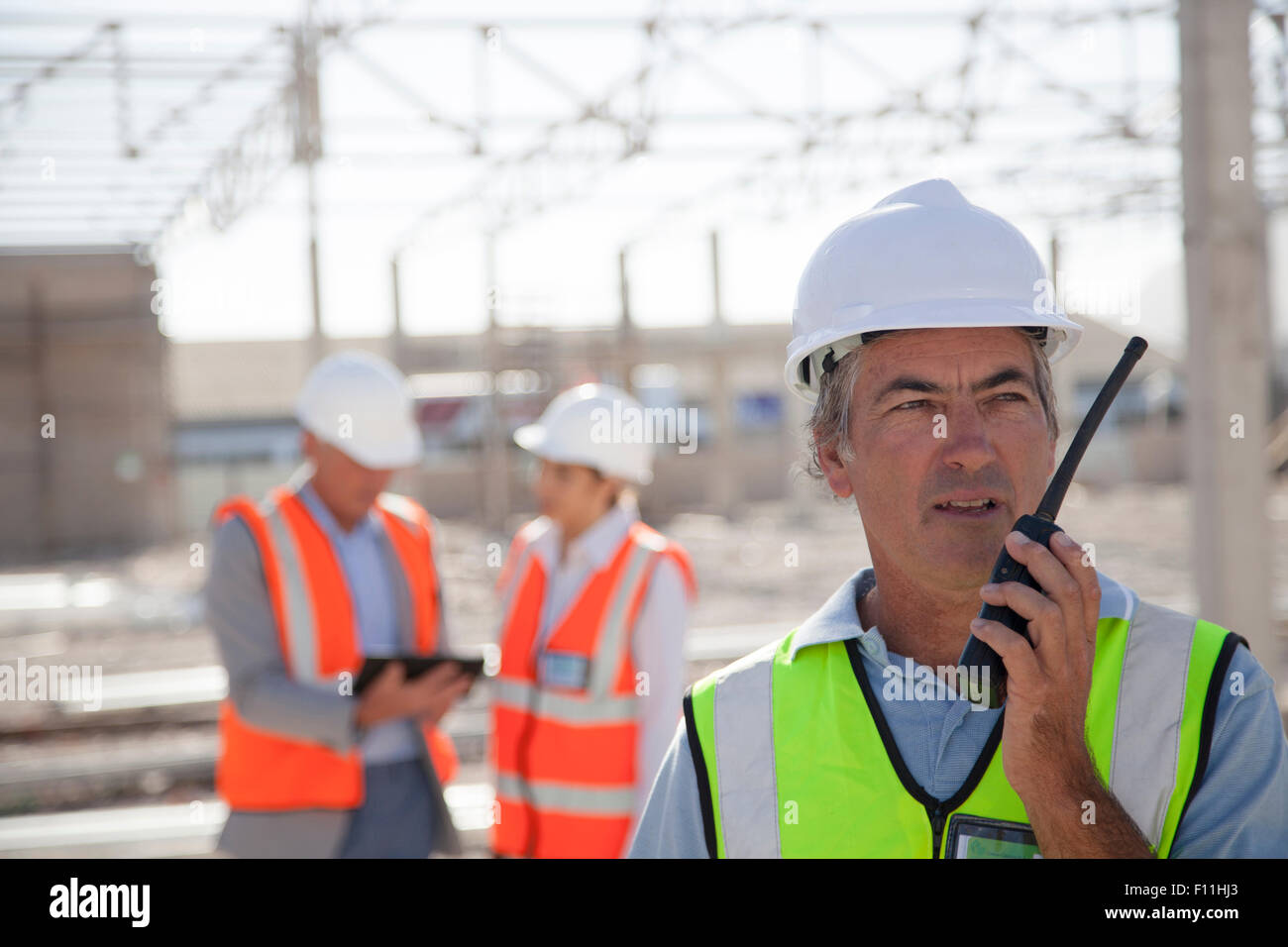 Worker talking on walkie-talkie at construction site Stock Photo