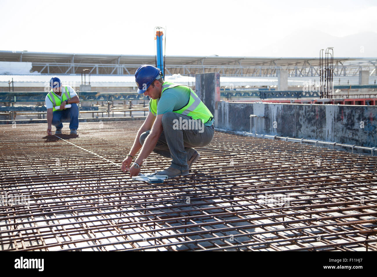Construction workers arranging rebar at construction site Stock Photo