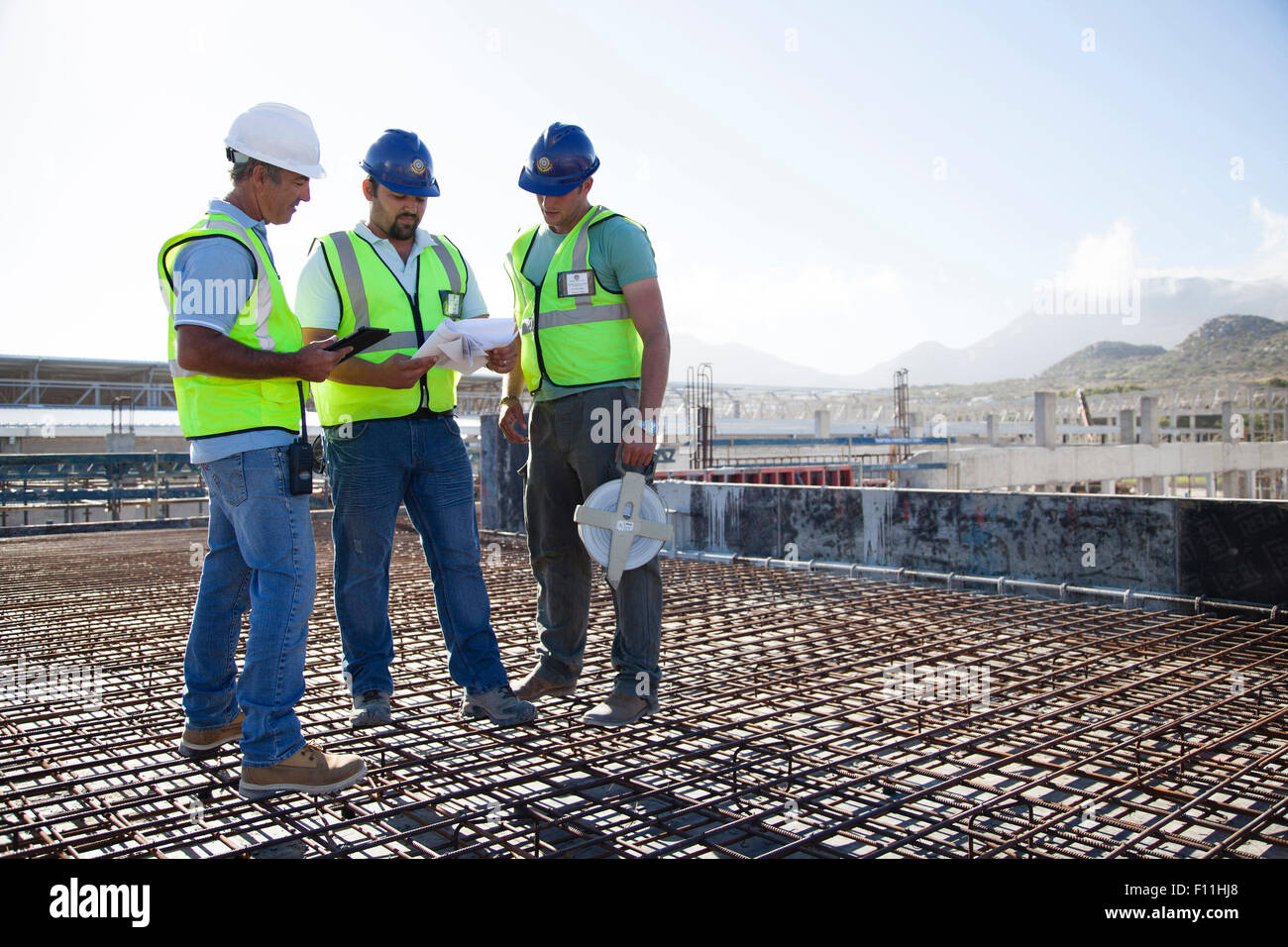 Construction workers talking on rebar at construction site Stock Photo