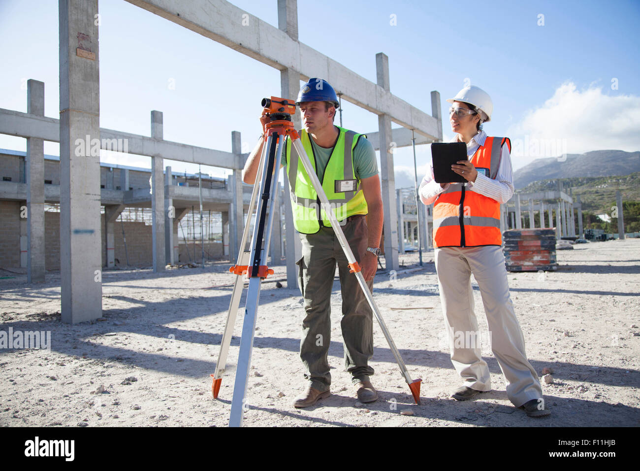 Surveyor and architect working at construction site Stock Photo