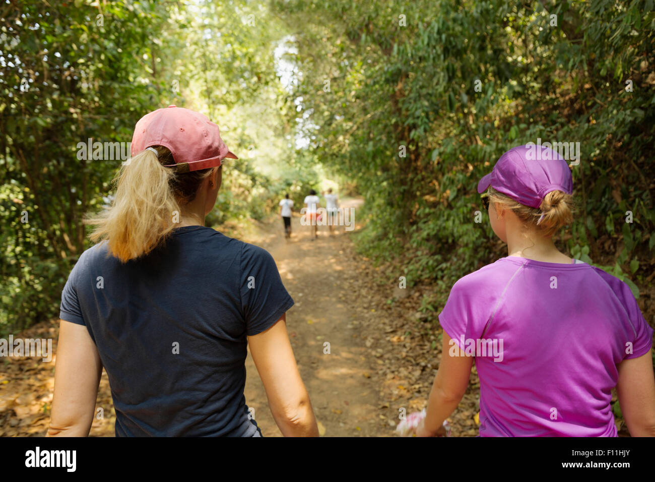 Women walking on remote dirt path Stock Photo