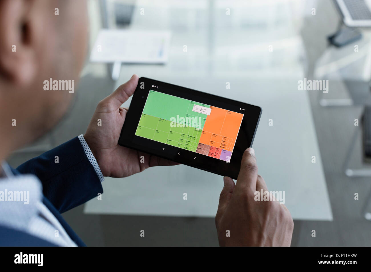 Hispanic businessman viewing graph on digital tablet Stock Photo