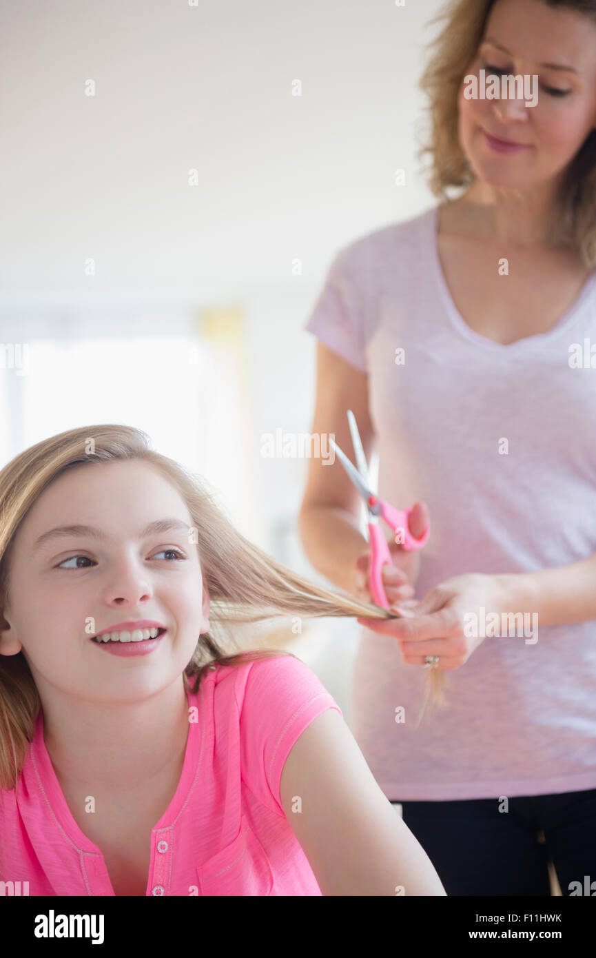 Caucasian mother cutting hair of daughter Stock Photo