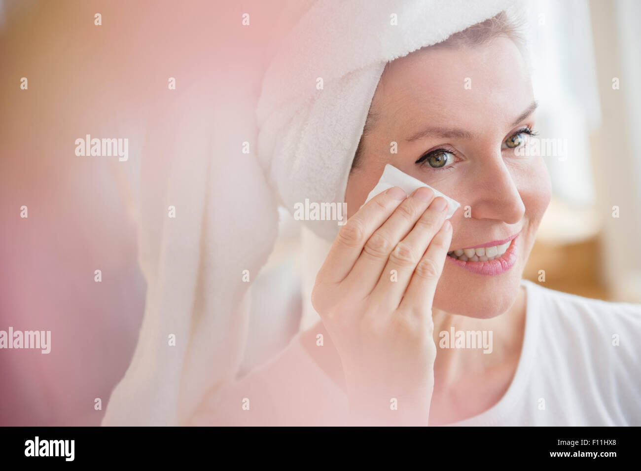 Caucasian woman wiping face Stock Photo