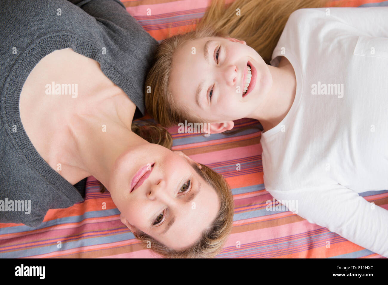 Caucasian mother and daughter laying on blanket Stock Photo