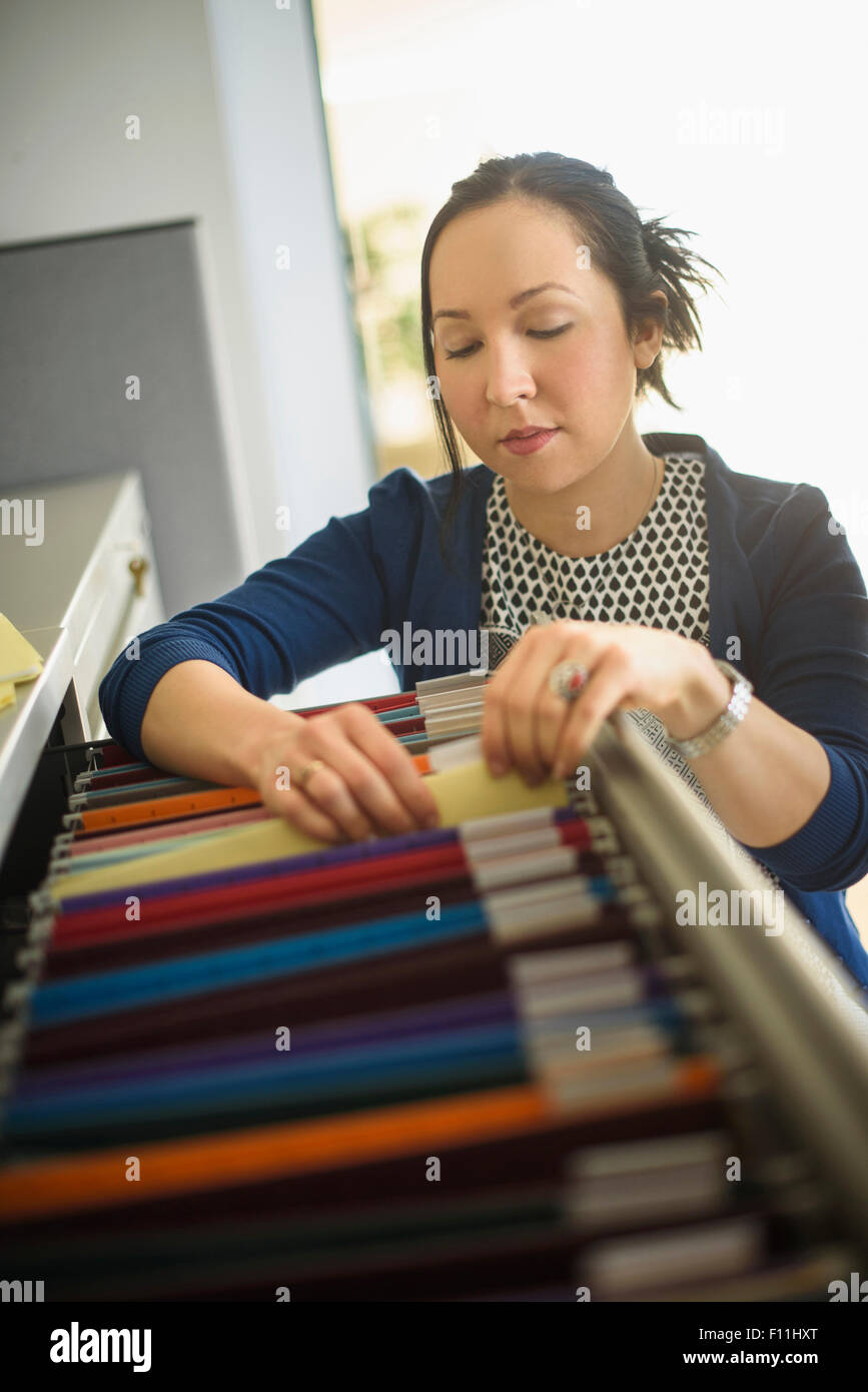 Mixed race businesswoman choosing files in office Stock Photo