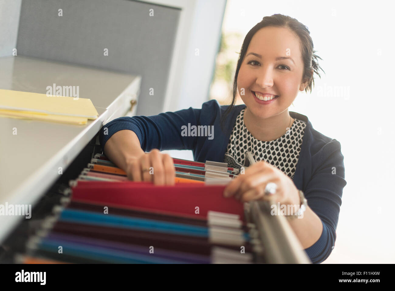 Mixed race businesswoman choosing files in office Stock Photo