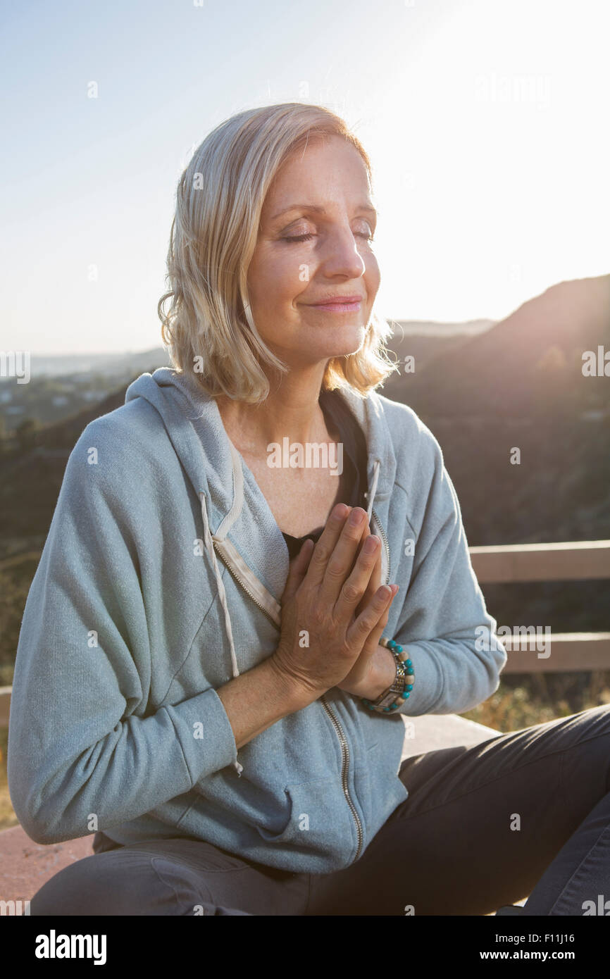 Caucasian woman meditating on hilltop Stock Photo - Alamy