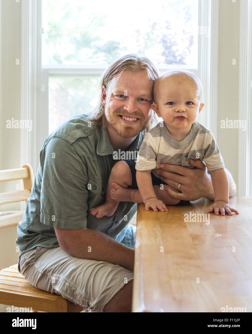Caucasian father and son smiling at table Stock Photo