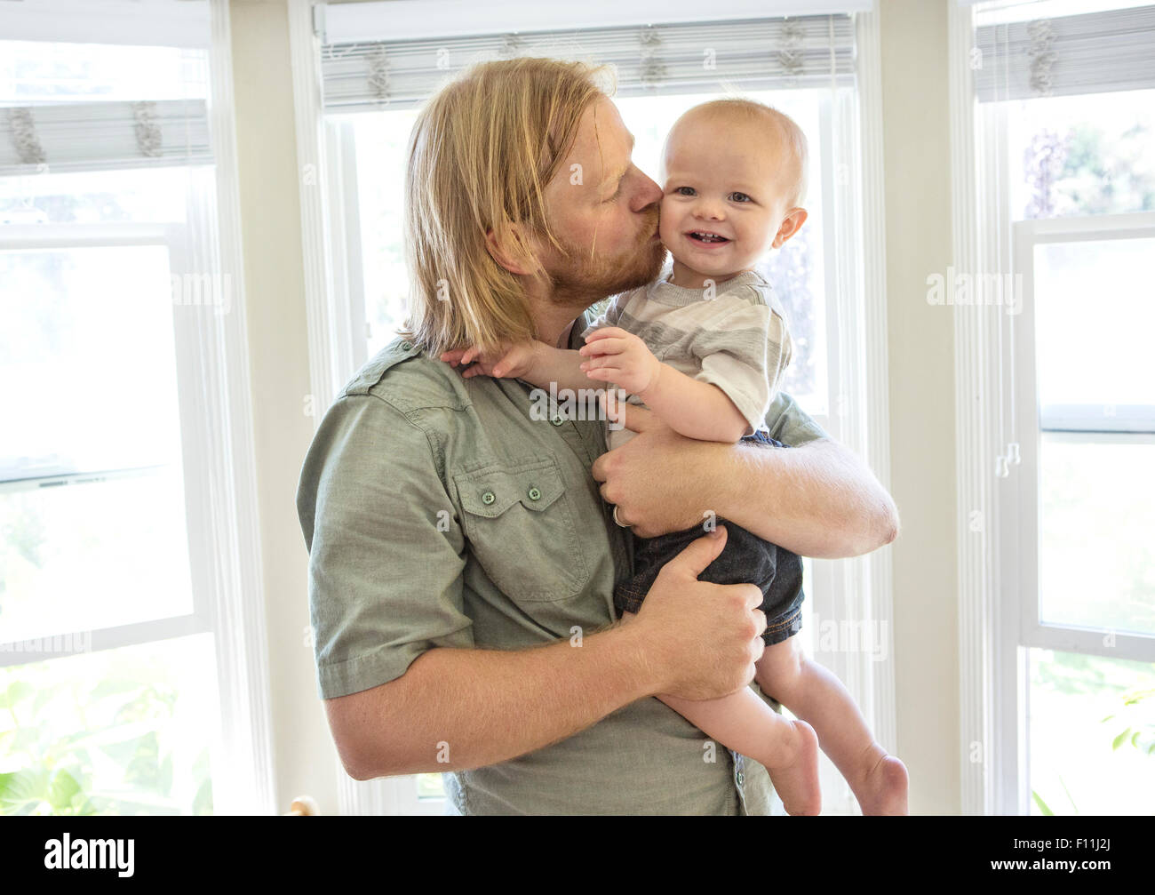 Caucasian father kissing son indoors Stock Photo