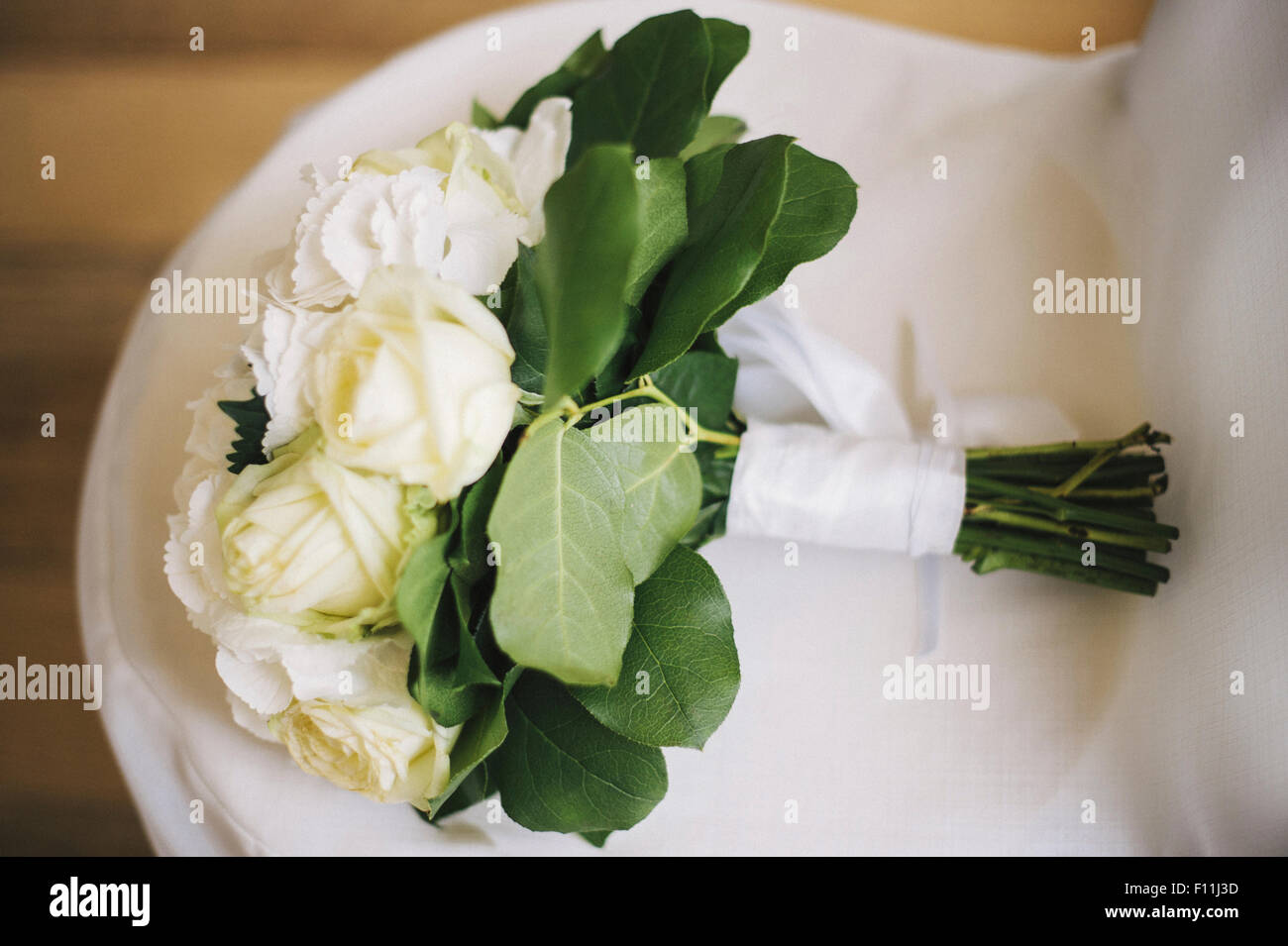 Close up of bouquet of flowers on wedding dress Stock Photo
