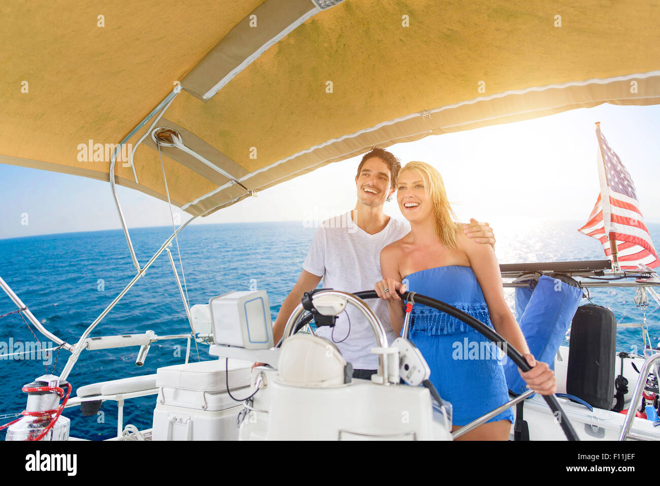 Couple steering boat on ocean Stock Photo