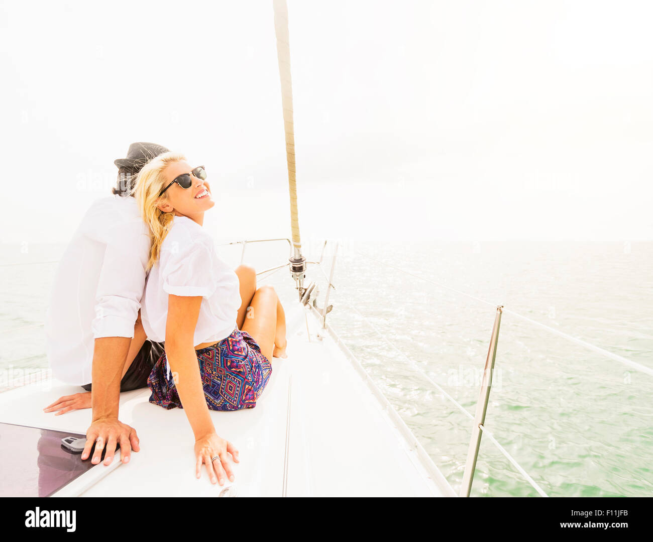 Couple cuddling on deck of sailboat Stock Photo