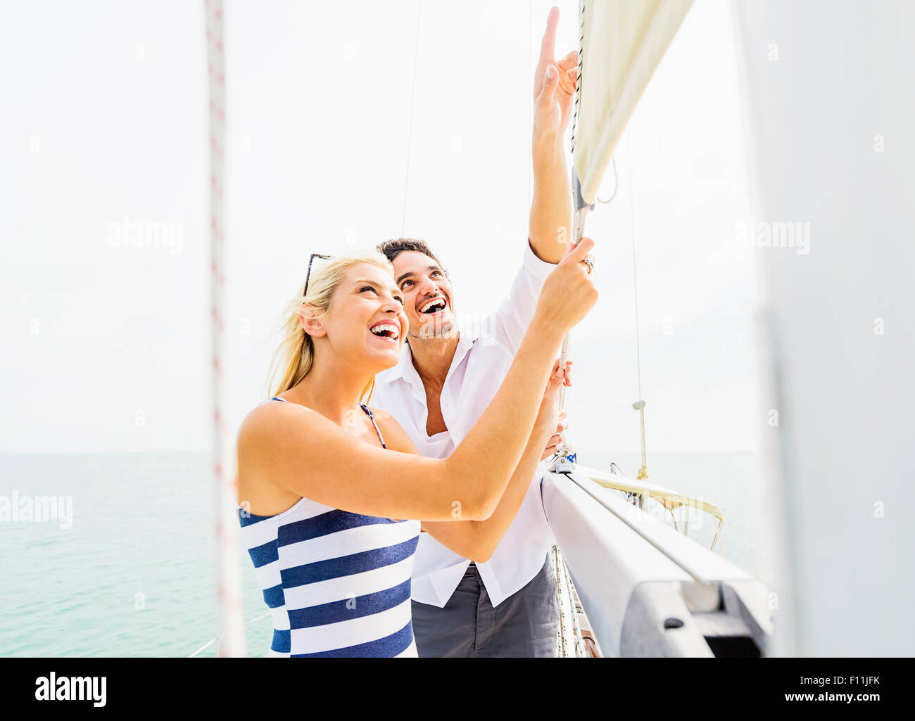 Couple adjusting rigging on sailboat Stock Photo