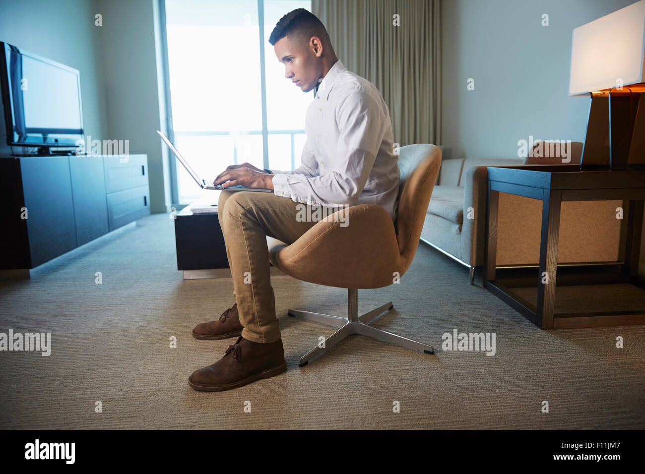 Black businessman using laptop in living room Stock Photo