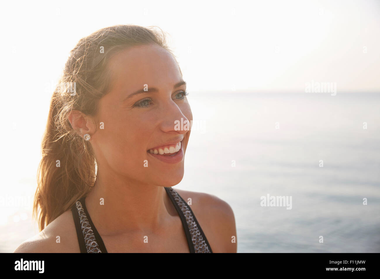 Close up of smiling woman on beach Stock Photo