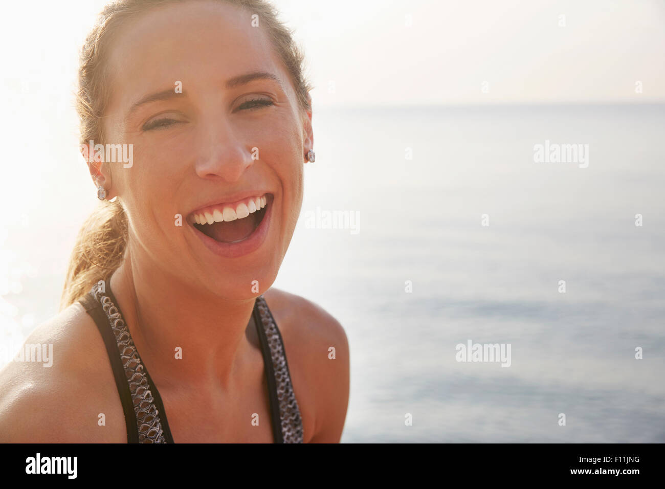 Close up of woman laughing on beach Stock Photo