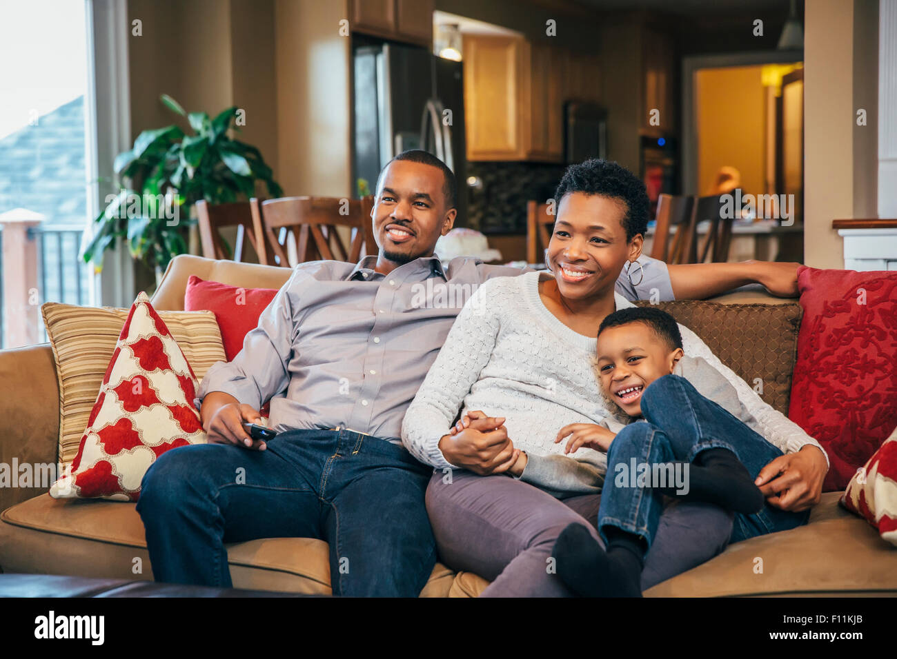 Black family watching television on sofa Stock Photo