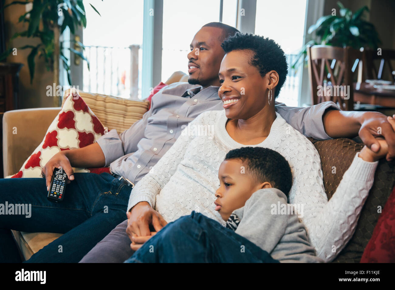 Black family watching television on sofa Stock Photo