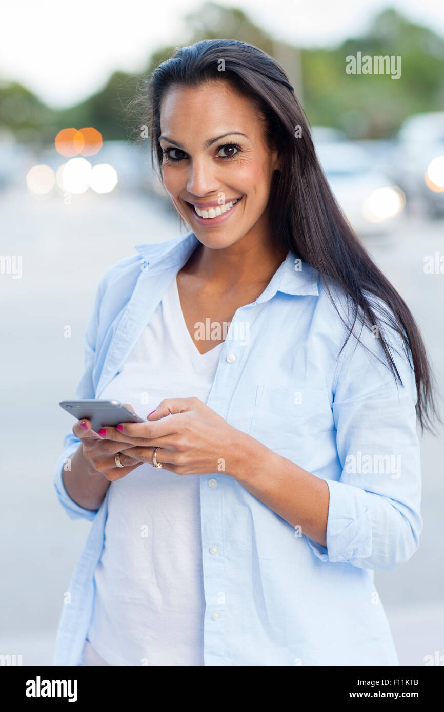 Hispanic woman using cell phone outdoors Stock Photo - Alamy