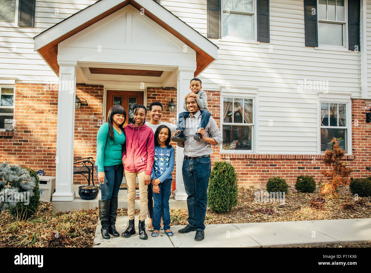 Black family smiling outside house Stock Photo - Alamy