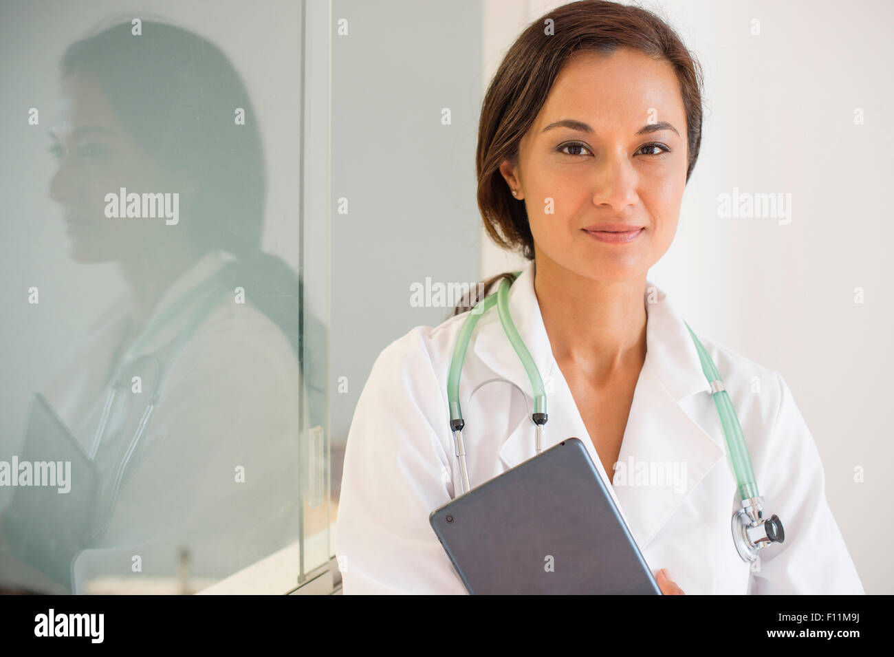 Mixed race doctor holding digital tablet Stock Photo