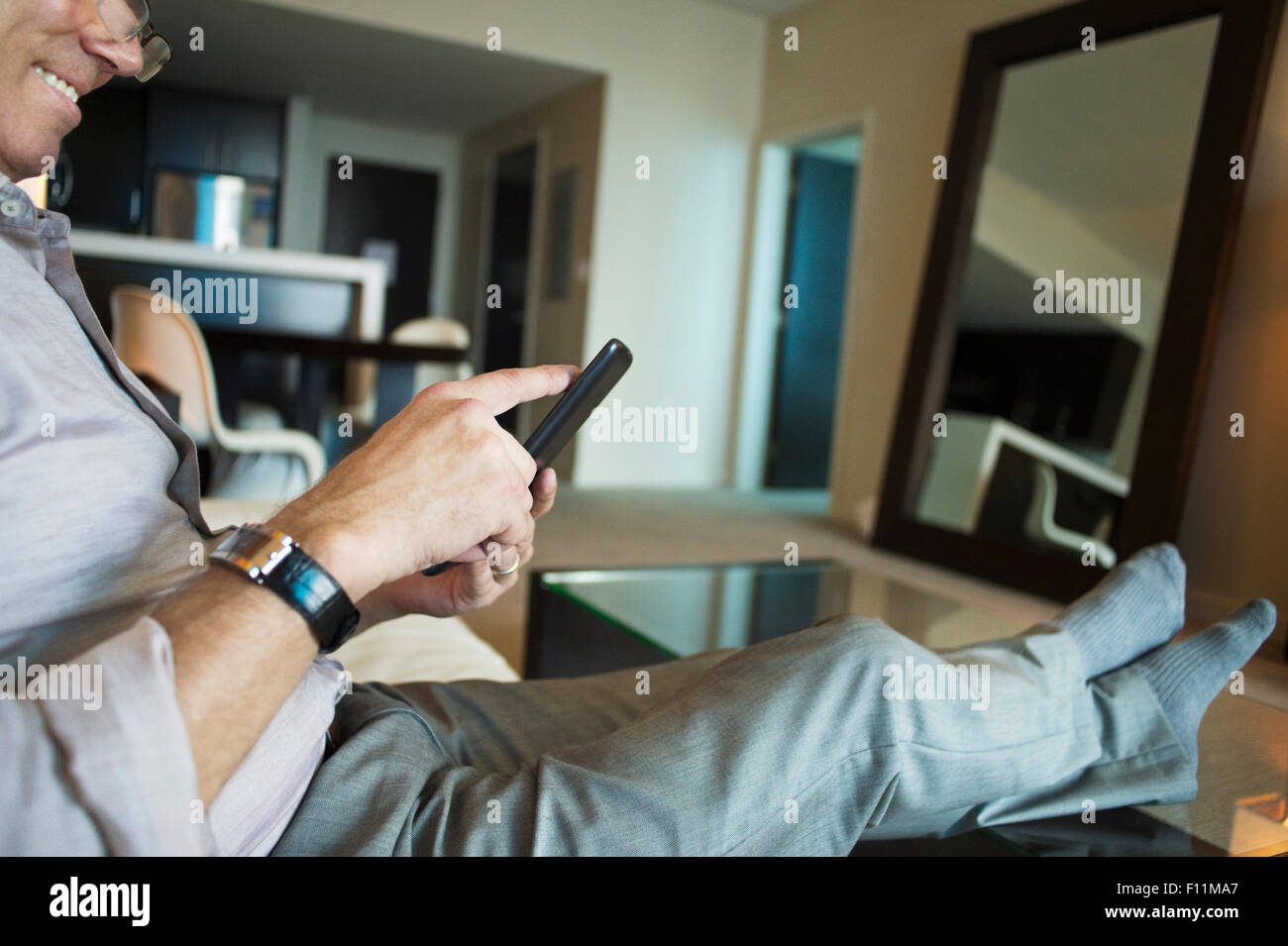 Caucasian businessman using cell phone in hotel room Stock Photo