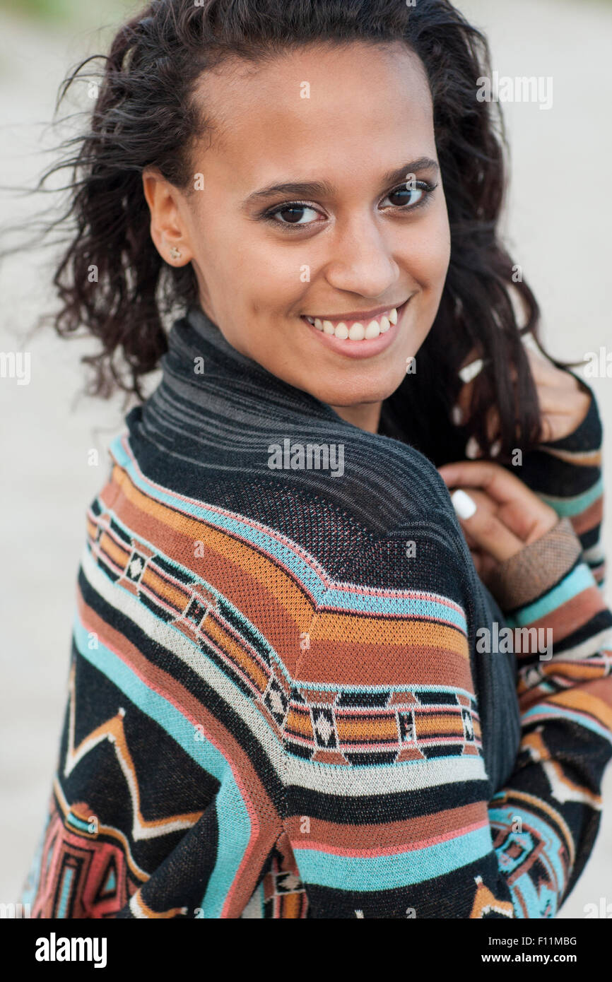 Mixed race woman wearing stylish sweater on beach Stock Photo