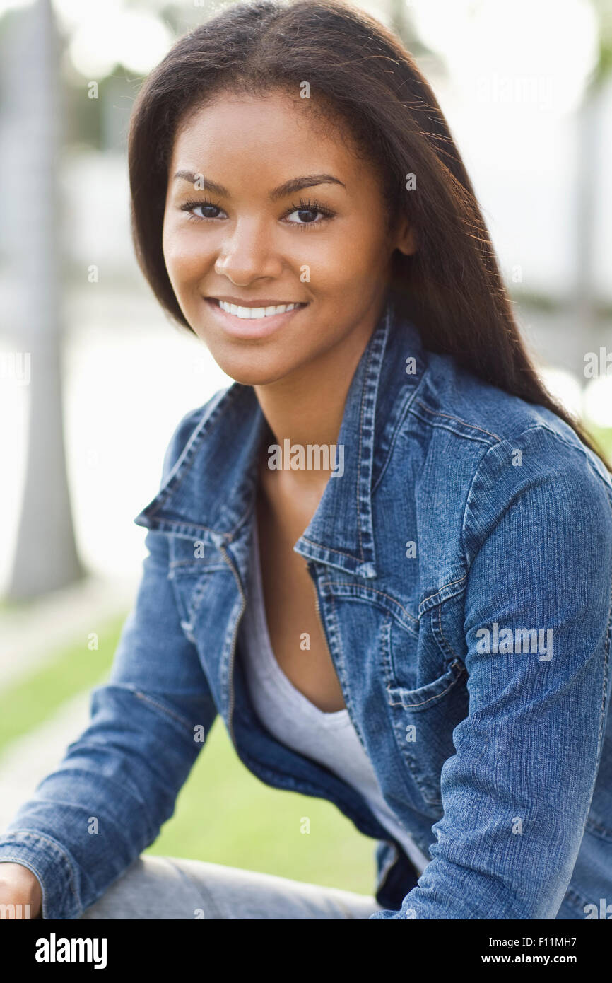 Close up of smiling Black woman sitting outdoors Stock Photo