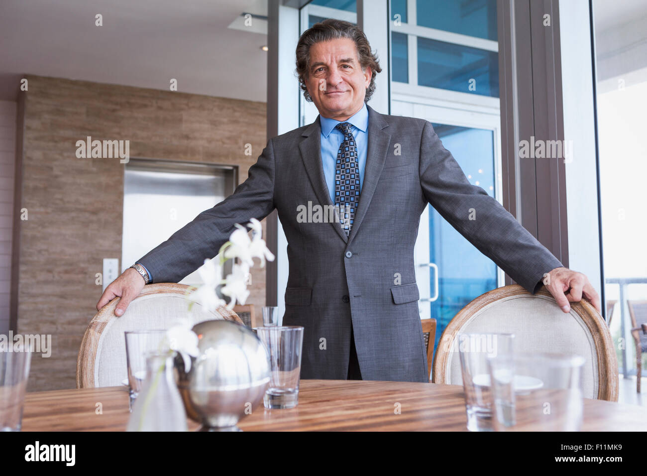 Businessman standing at dining table Stock Photo