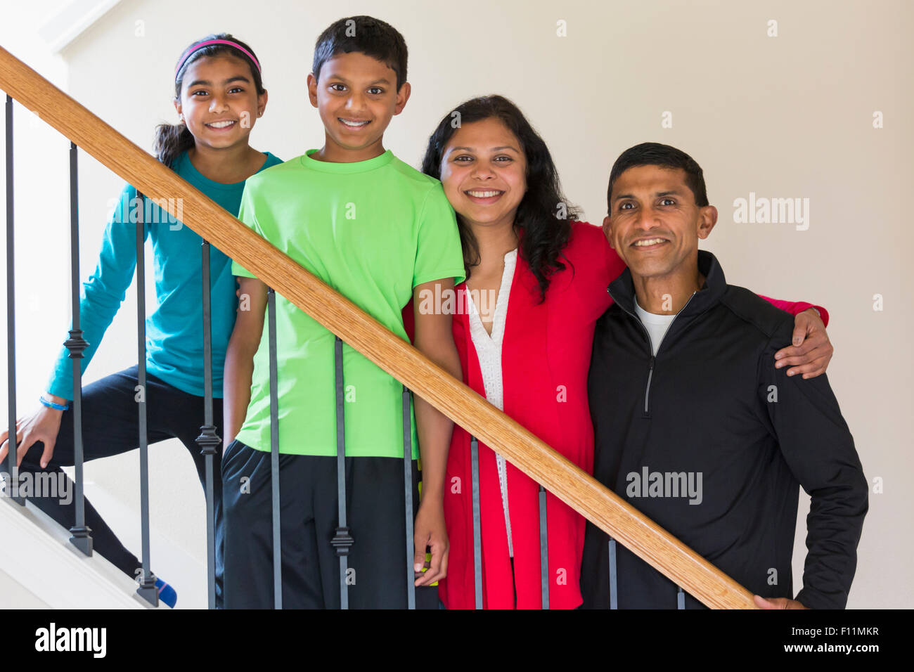 Close up of Indian family smiling on staircase Stock Photo