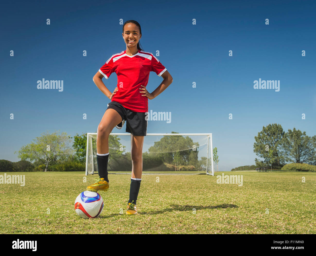 Mixed race soccer player standing on field Stock Photo
