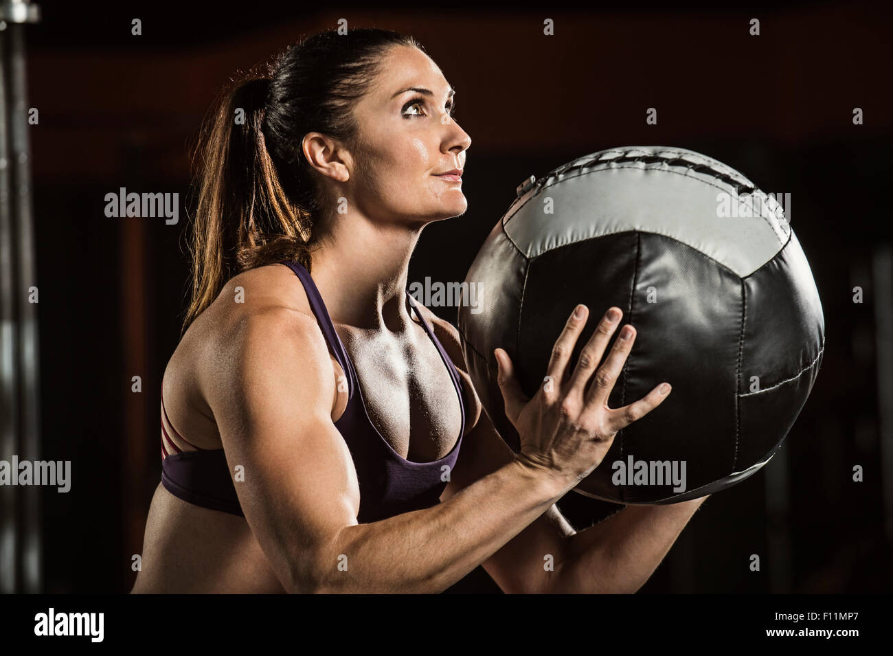 Caucasian athlete lifting resistance ball in gym Stock Photo
