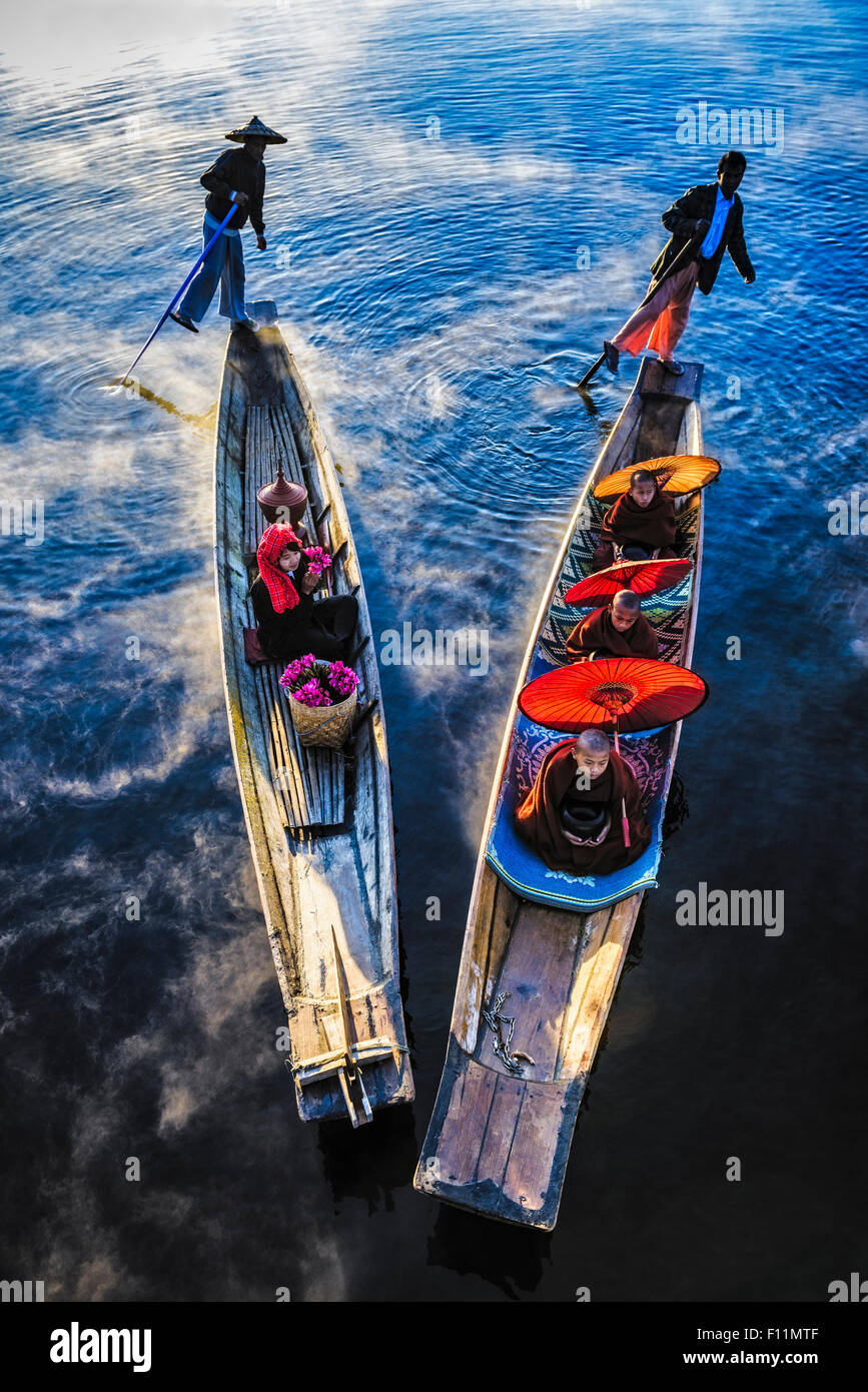 Asian gondoliers rowing canoes on river Stock Photo