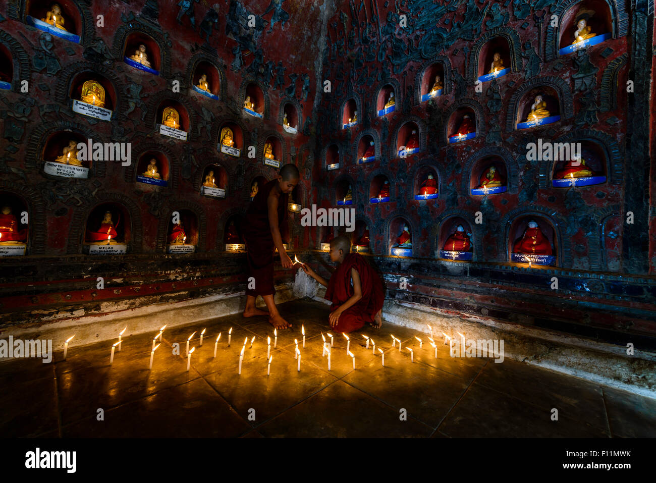 Asian monks-in-training lighting candles in ancient temple Stock Photo ...