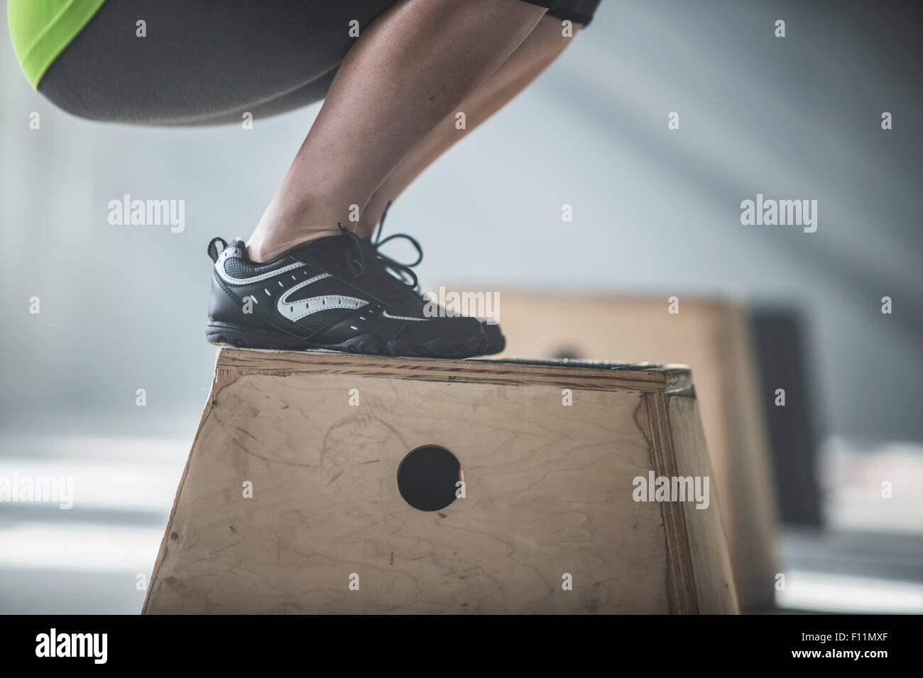 Athlete crouching on platform in gym Stock Photo