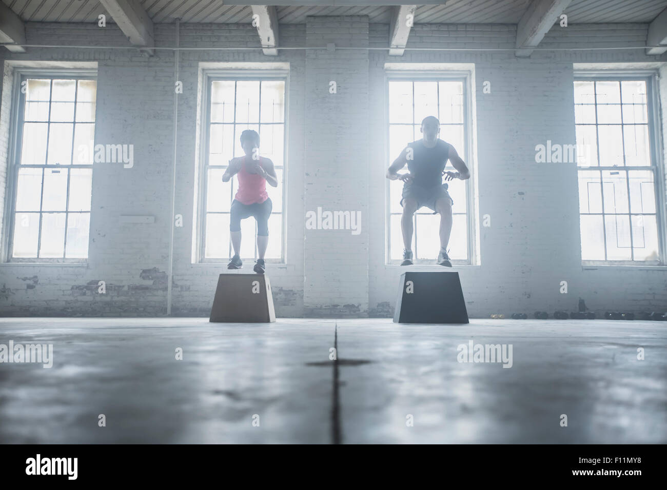 Silhouette of athletes jumping on platforms Stock Photo