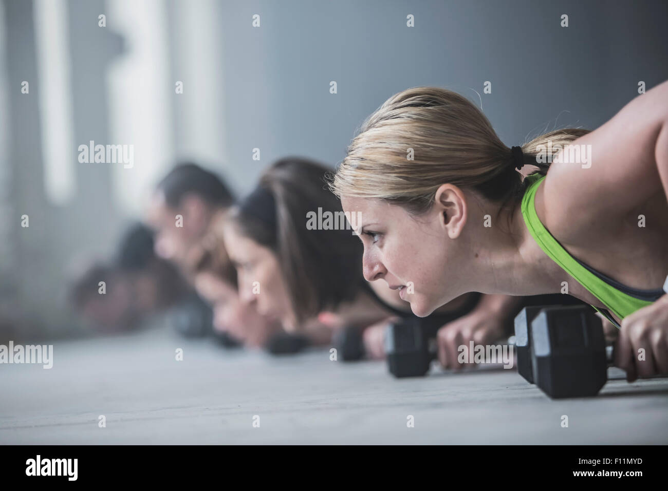 Athletes doing pushups and lifting weights on floor Stock Photo Alamy