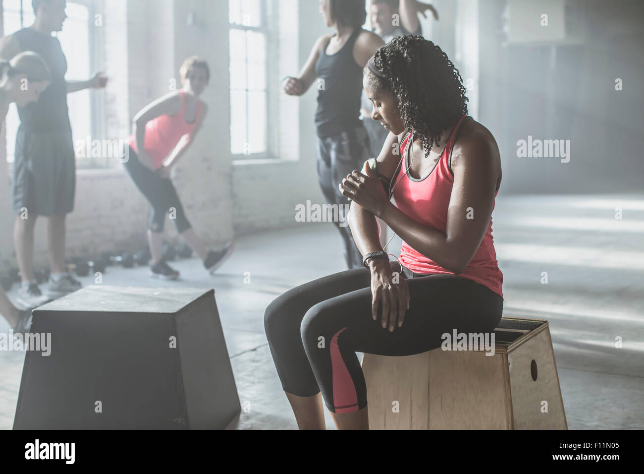 Athlete listening to mp3 player in gym Stock Photo - Alamy