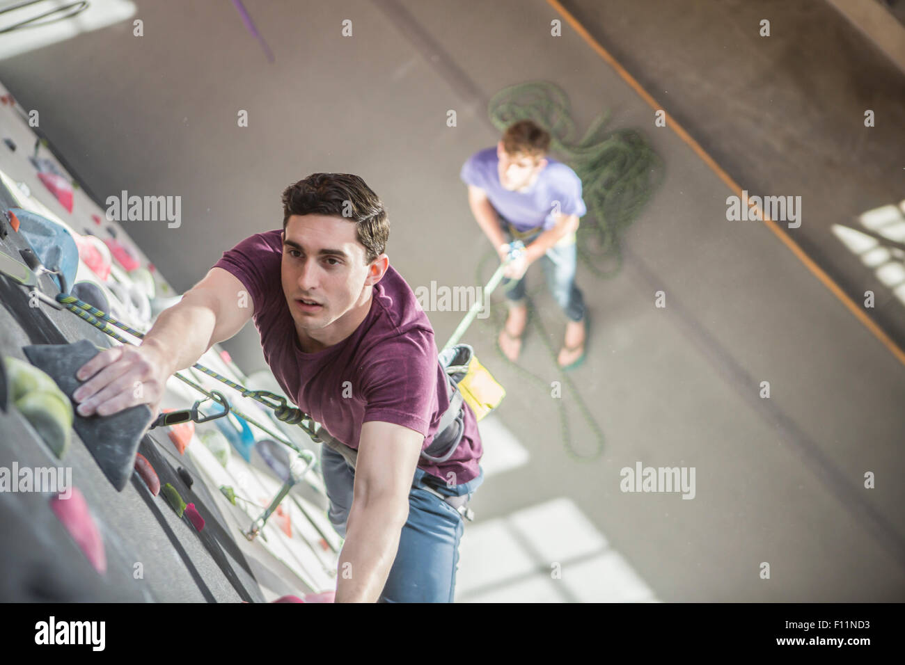 High angle view of athlete climbing rock wall in gym Stock Photo