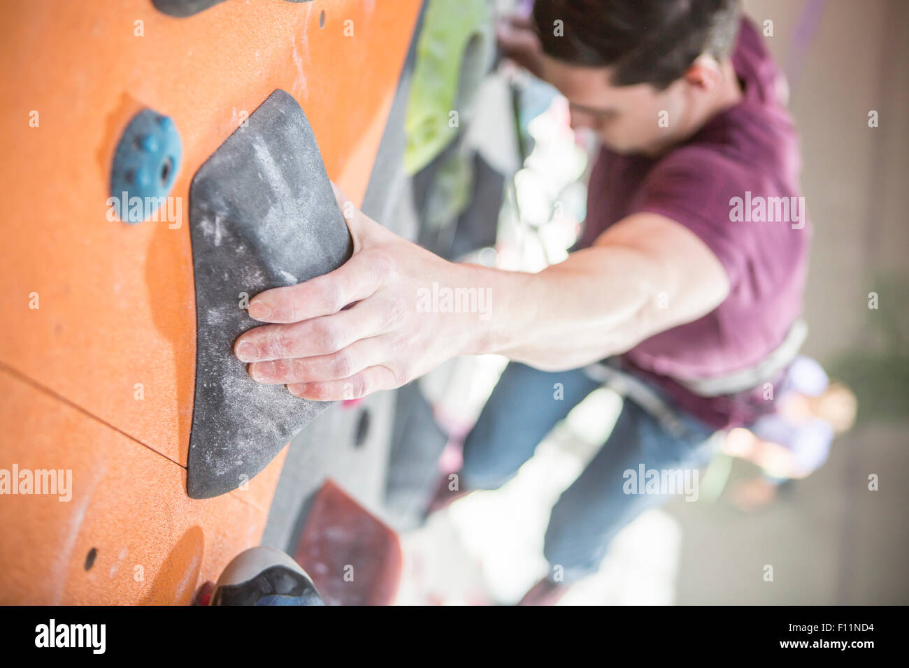 High angle view of athlete climbing rock wall in gym Stock Photo