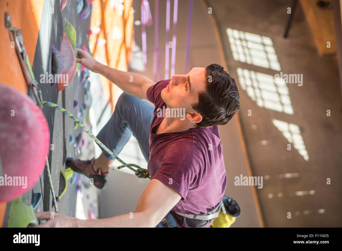High angle view of athlete climbing rock wall in gym Stock Photo