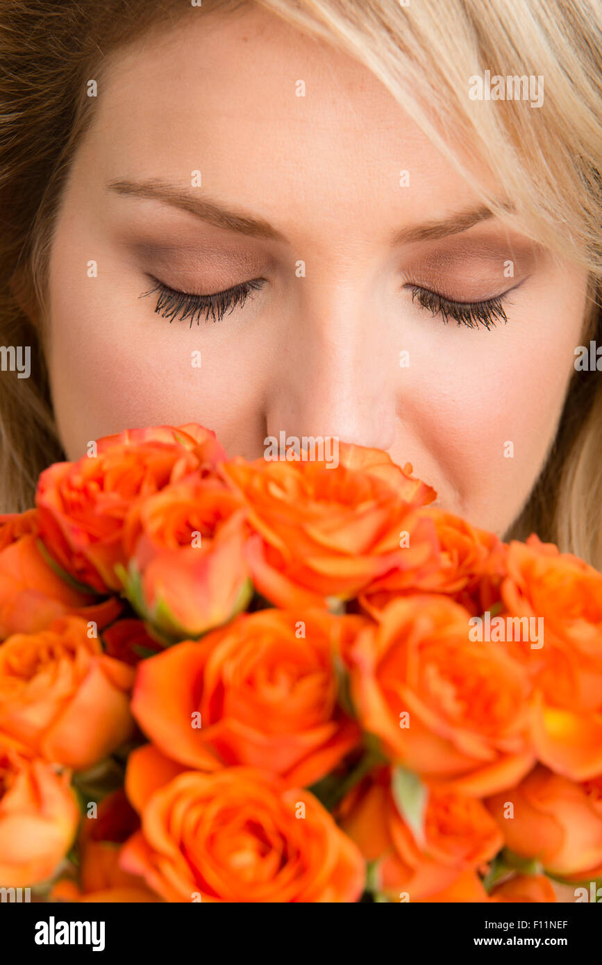 Caucasian woman smelling bouquet of flowers Stock Photo