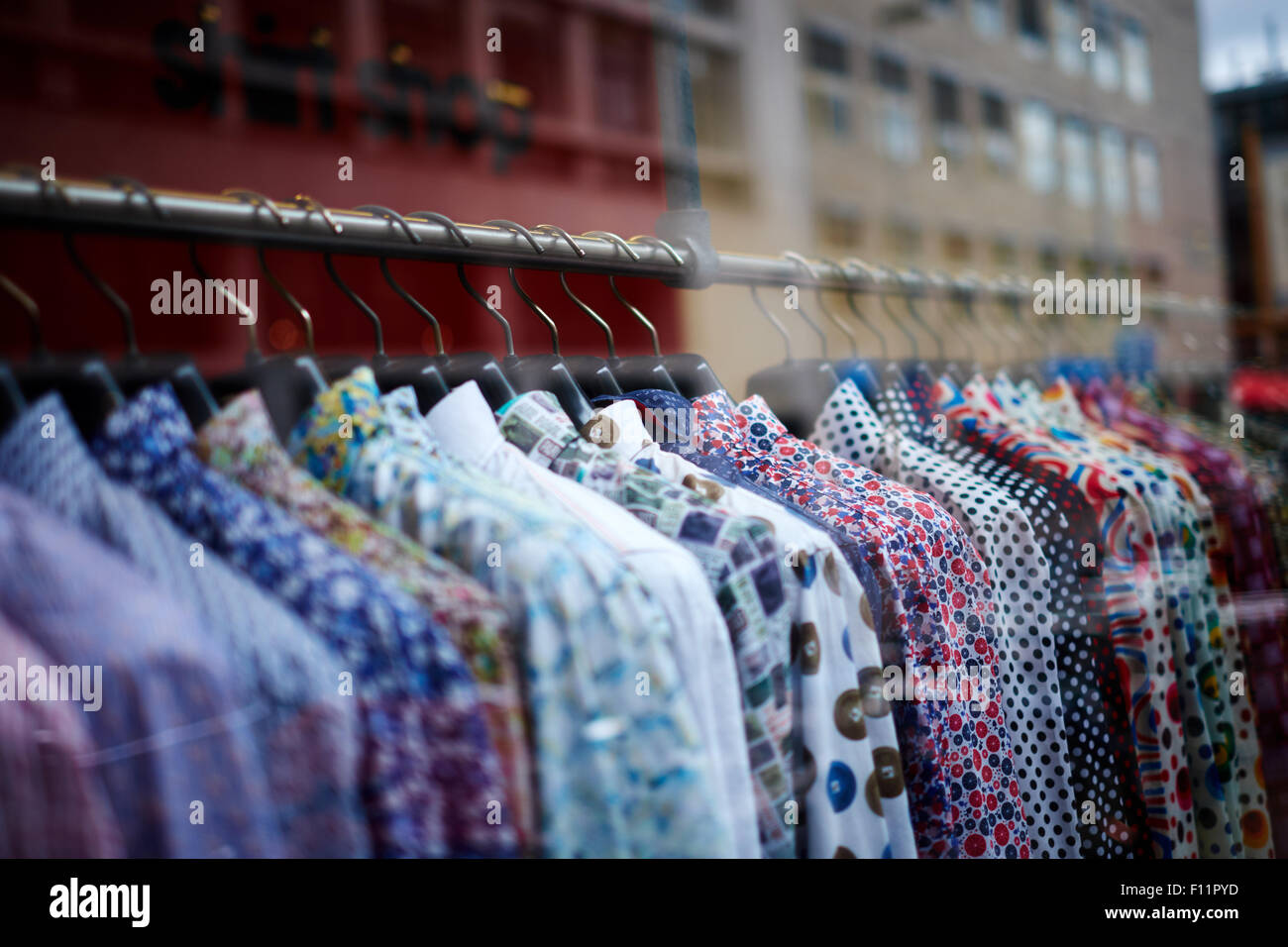 Rack of colourful shirts in a shop. Stock Photo