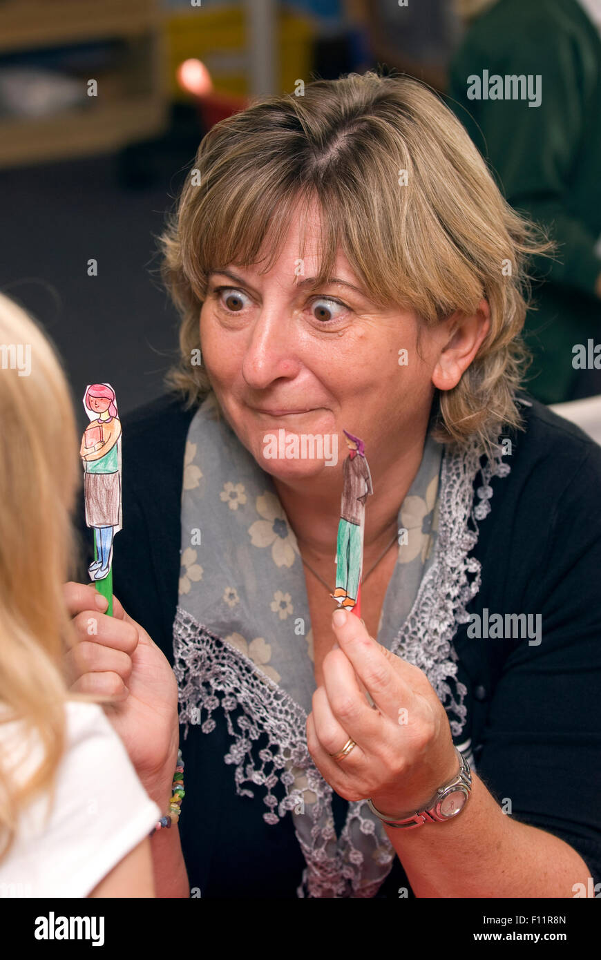 Member of primary school teaching staff at work in classroom, UK. Stock Photo