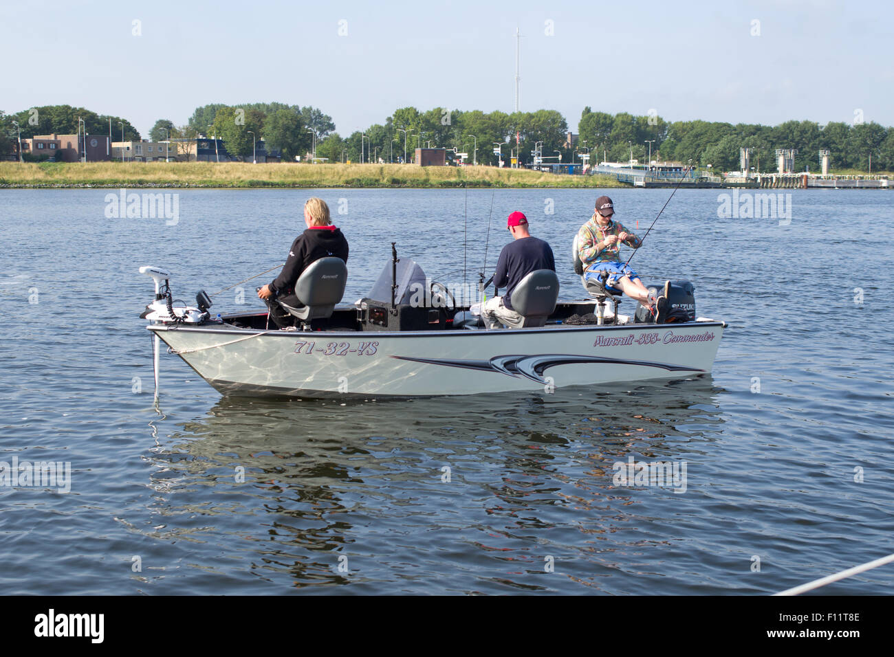 Three men in a boat fishing Stock Photo - Alamy