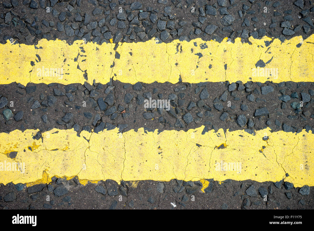 Double yellow lines on a tarmac road Stock Photo - Alamy