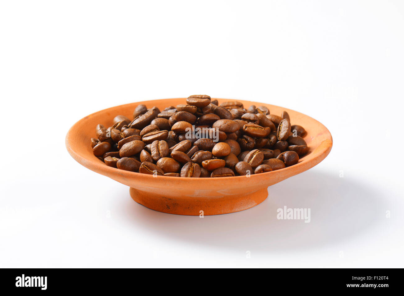 Medium roasted coffee beans in terracotta bowl Stock Photo - Alamy