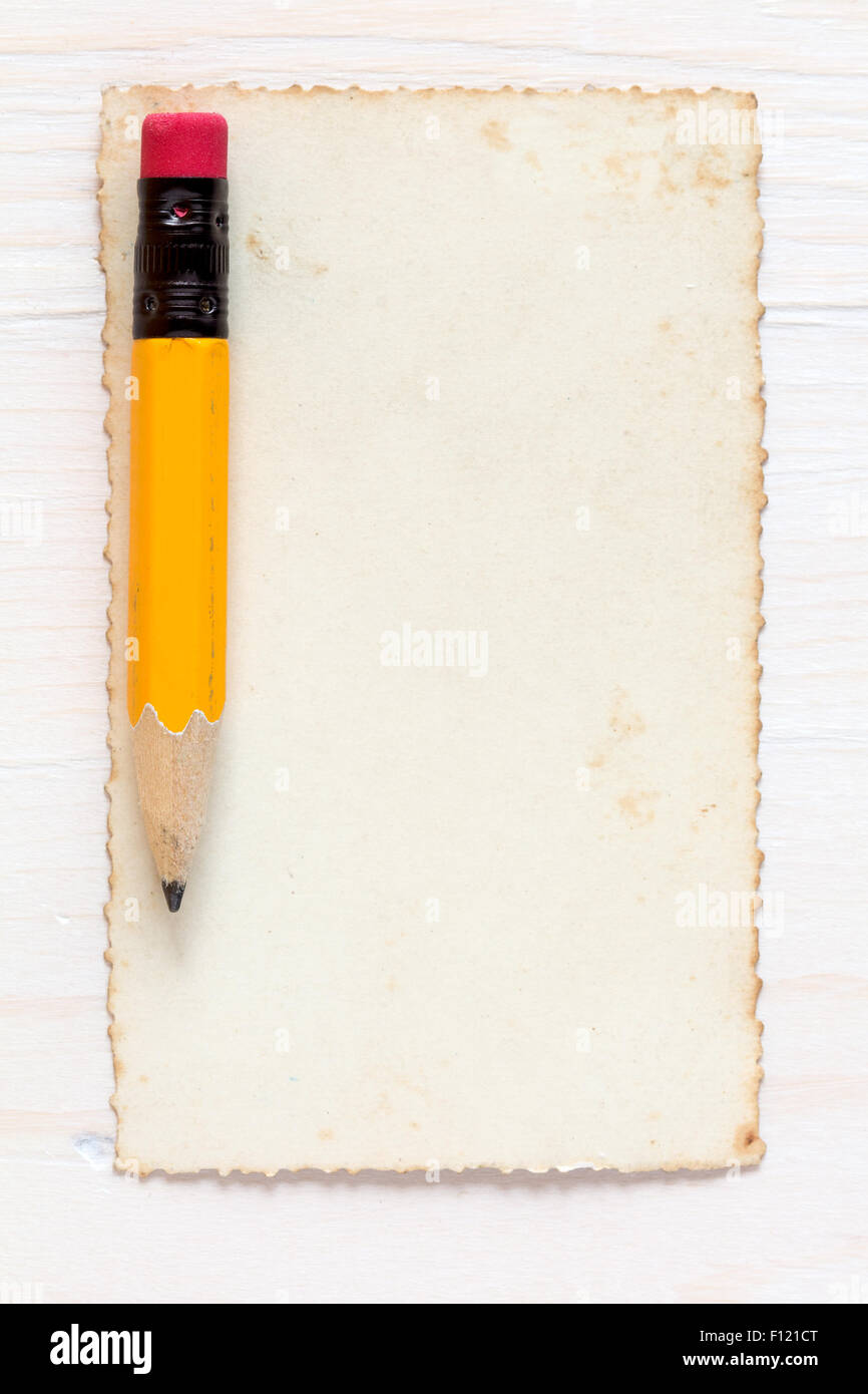 Yellow pencil with old paper on wood Stock Photo